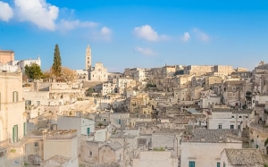 panoramic view of typical stones (Sassi di Matera) and church of Matera UNESCO European Capital of Culture 2019 under blue sky